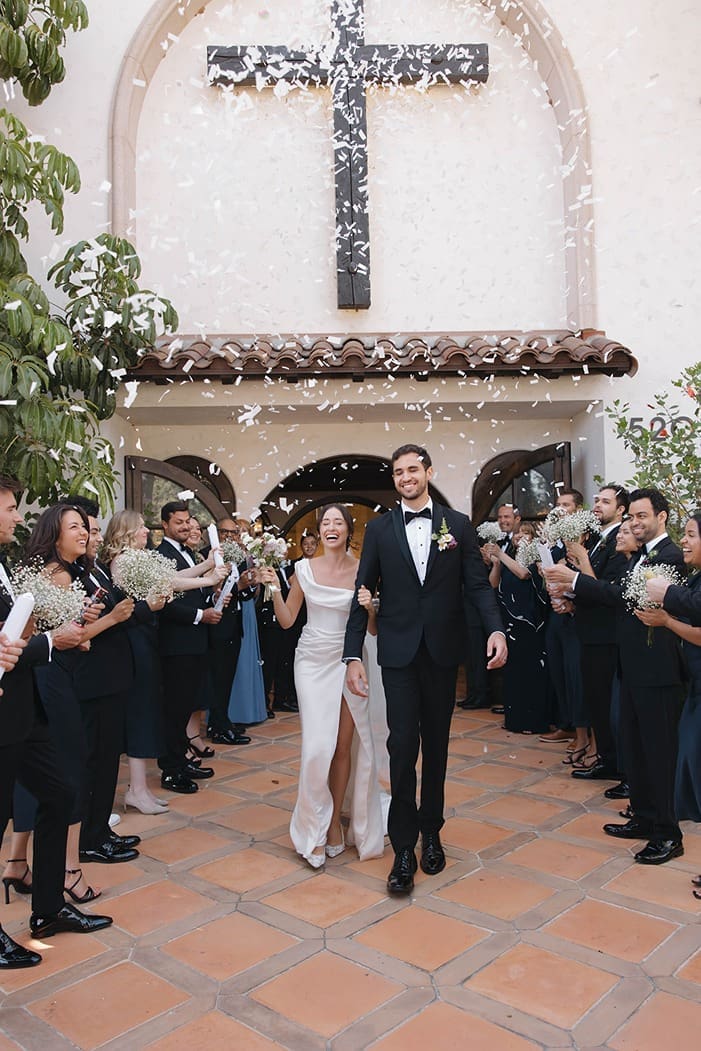 the bride and groom walking out of their bilingual wedding