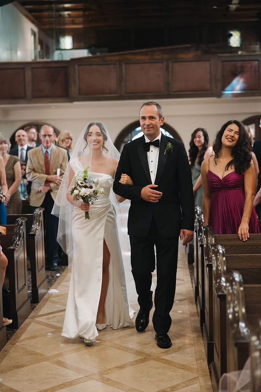 the bride walking down the aisle for her ​bilingual wedding ceremony