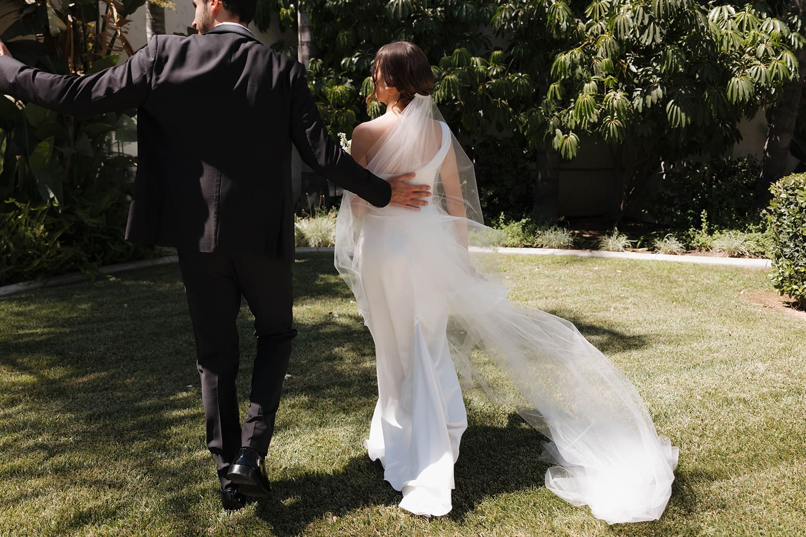 natural wedding photo of a bride and groom walking off