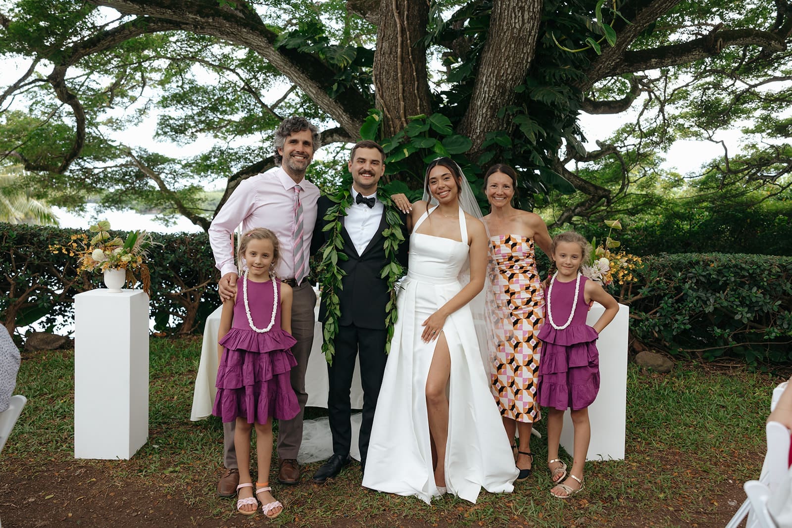 natural wedding photo of a bride and groom posing with family members