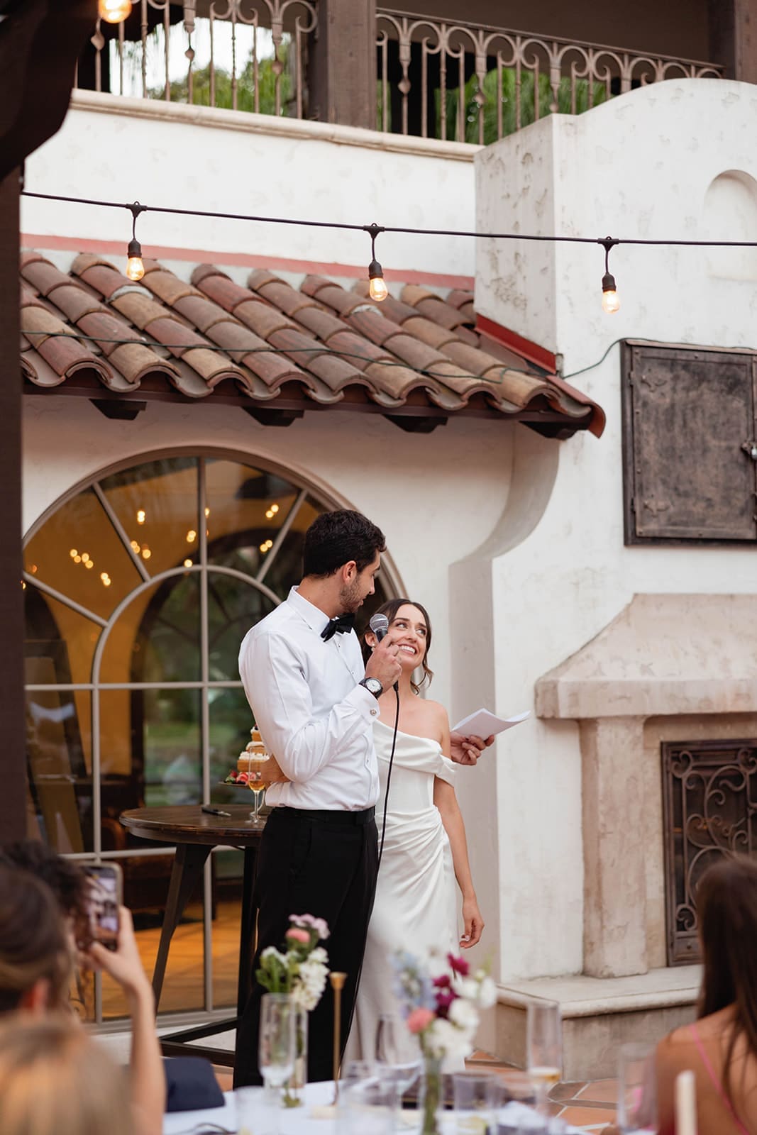 bride and groom during their wedding reception speech - a perfect example of how to feel natural in wedding photos