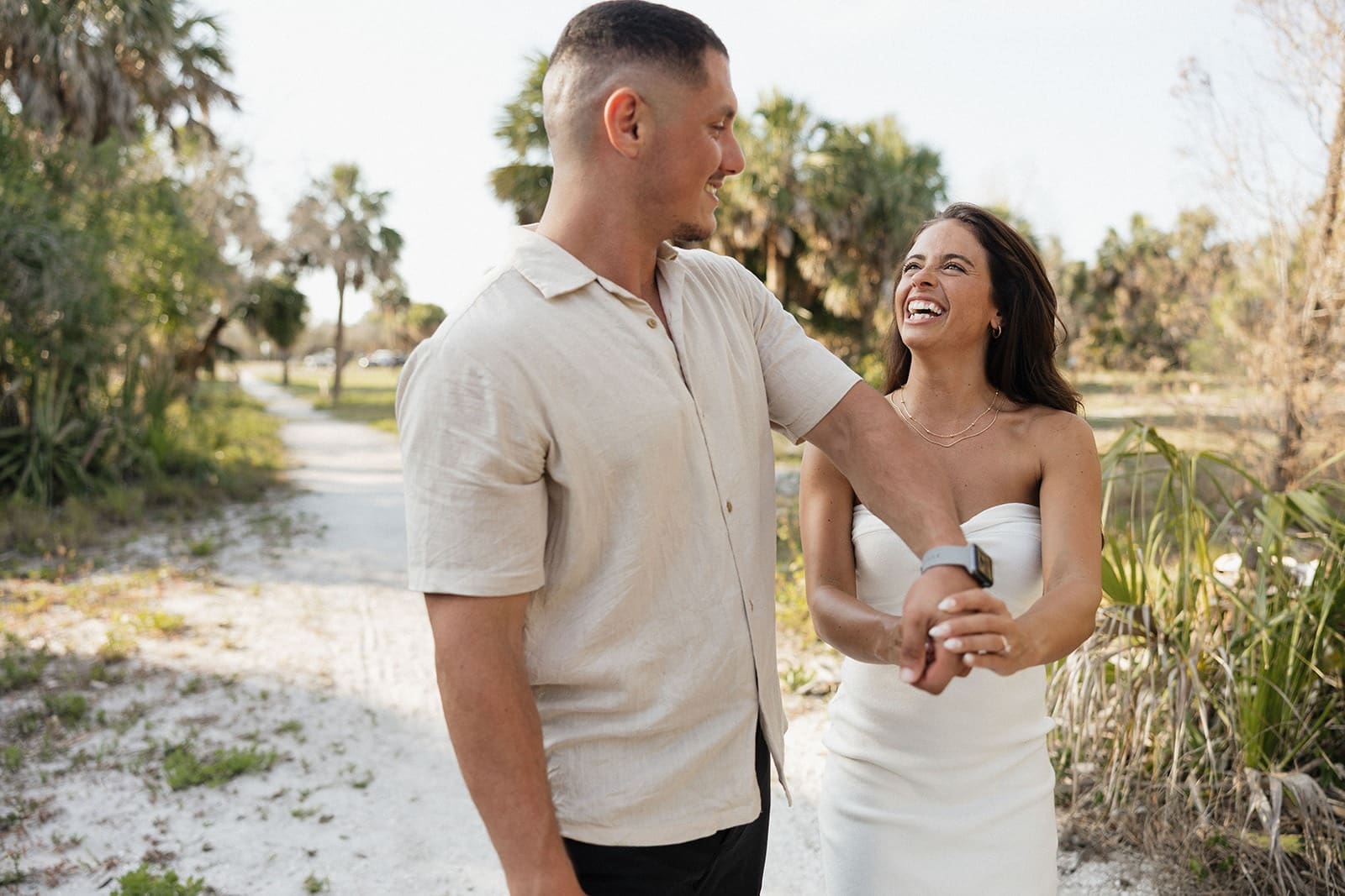 the perfect examples of how to smile naturally for wedding photos - candid image of a bride and groom laughing