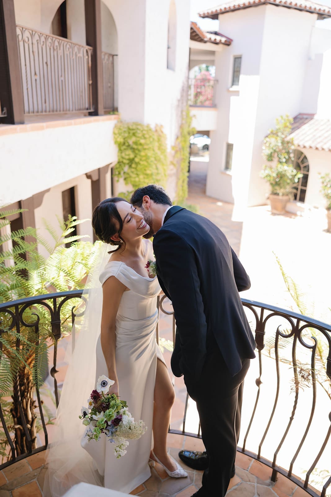 candid photo of a groom kissing his bride in the neck, a beautiful natural wedding photo