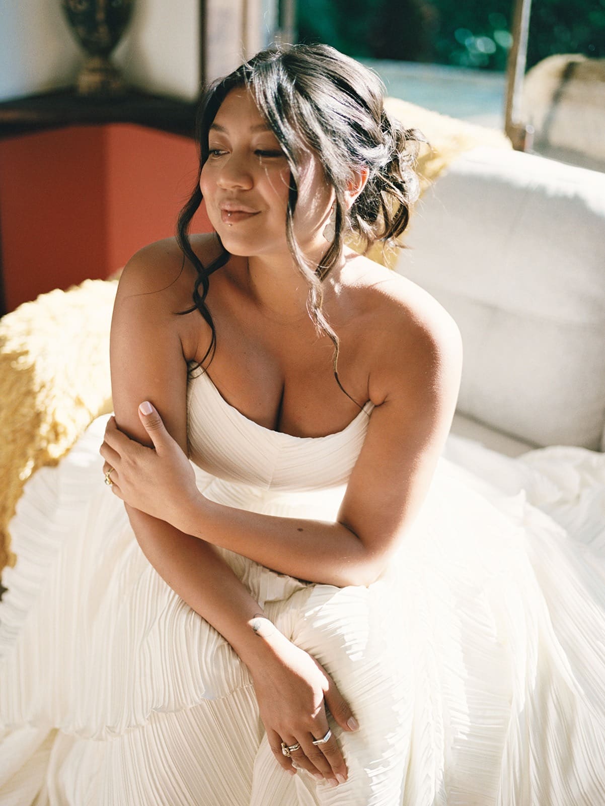 portrait of a beautiful bride sitting on a couch in the sun at her Rincón wedding venue