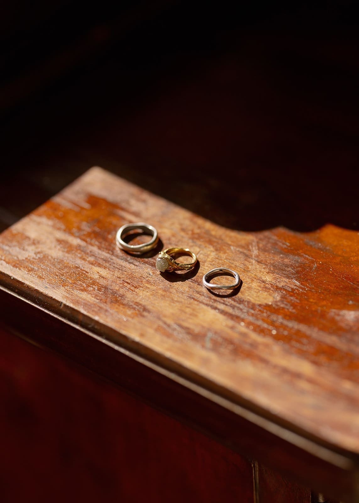 photo of wedding rings laid out on a wooden table at a wedding venue in rincon