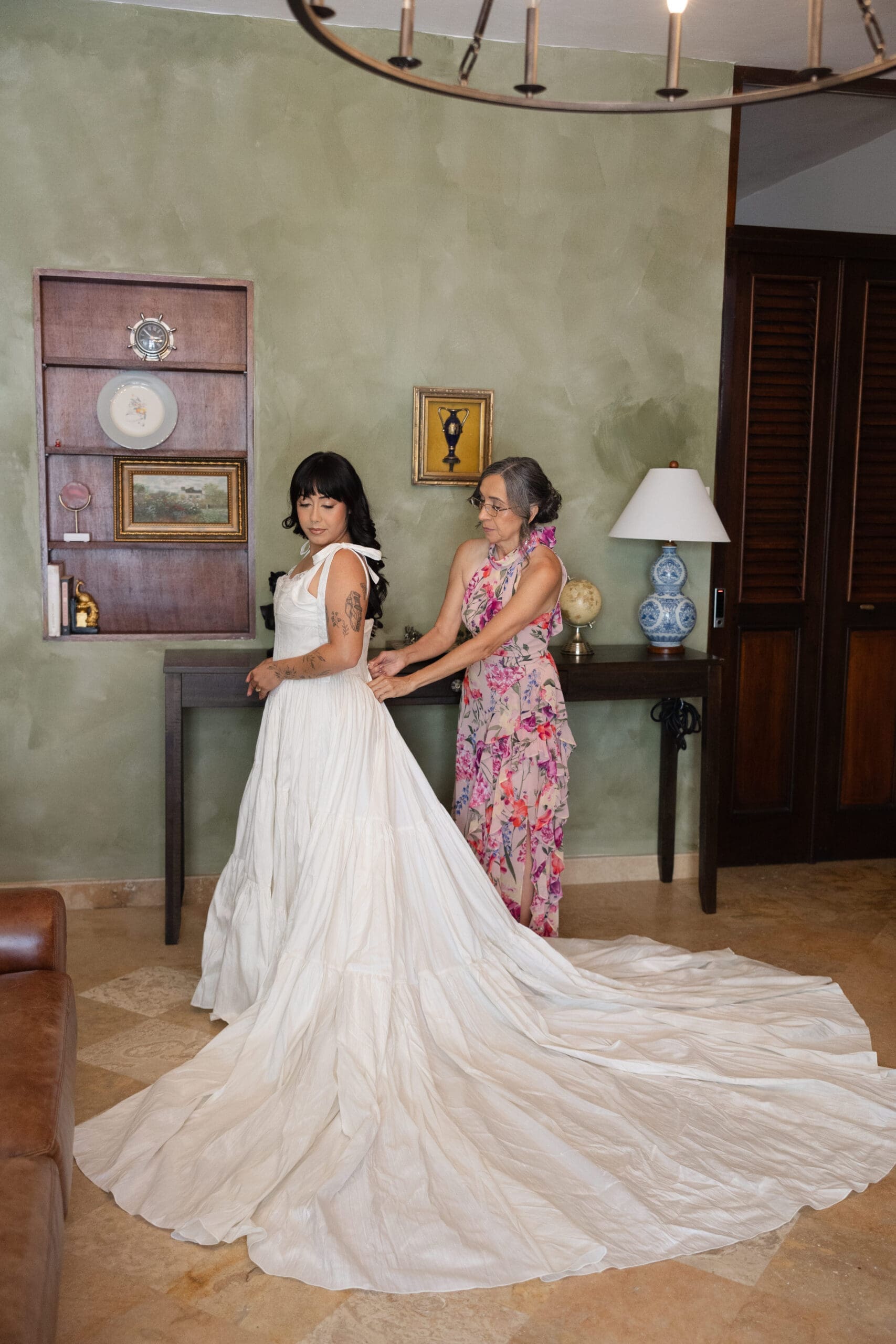 Bride getting ready indoors with help from a family member before her San Juan wedding