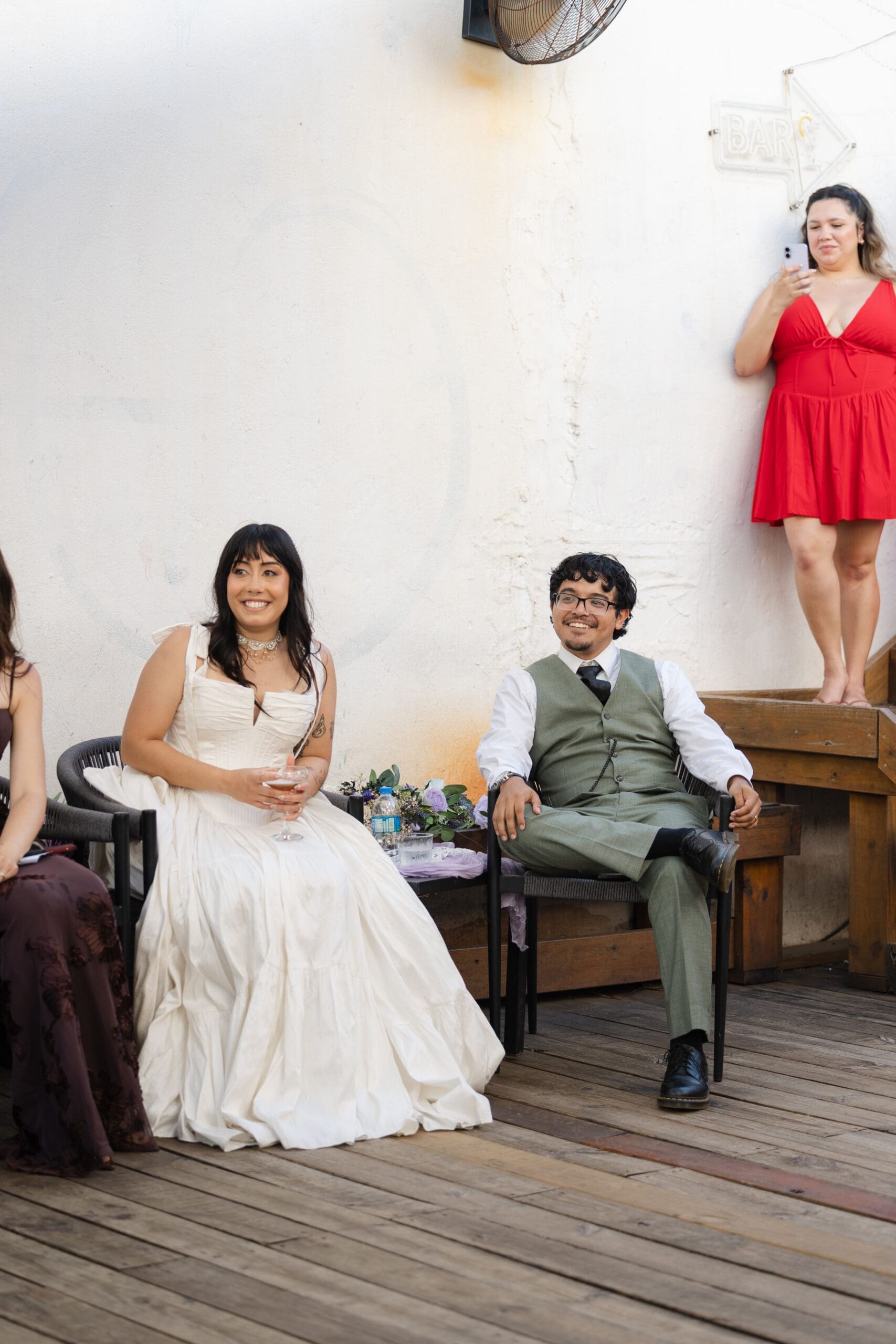 Newlyweds sitting together during their outdoor wedding reception in San Juan