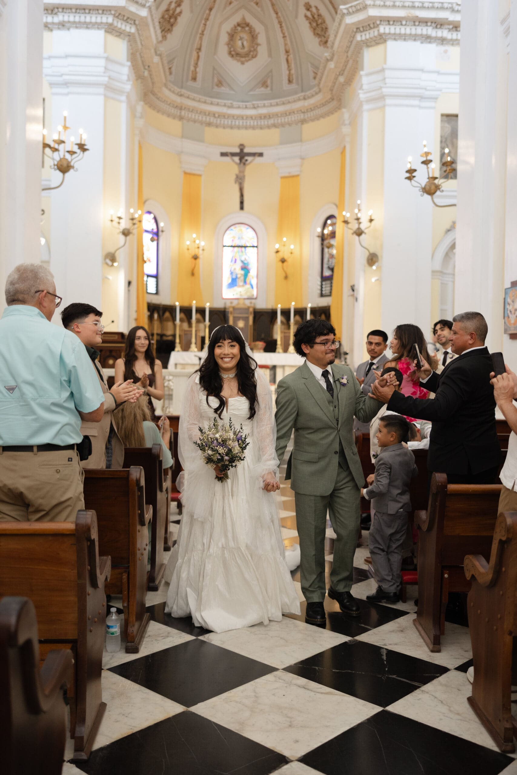 Newlyweds walking down the aisle together after their church wedding ceremony in San Juan, Puerto Rico