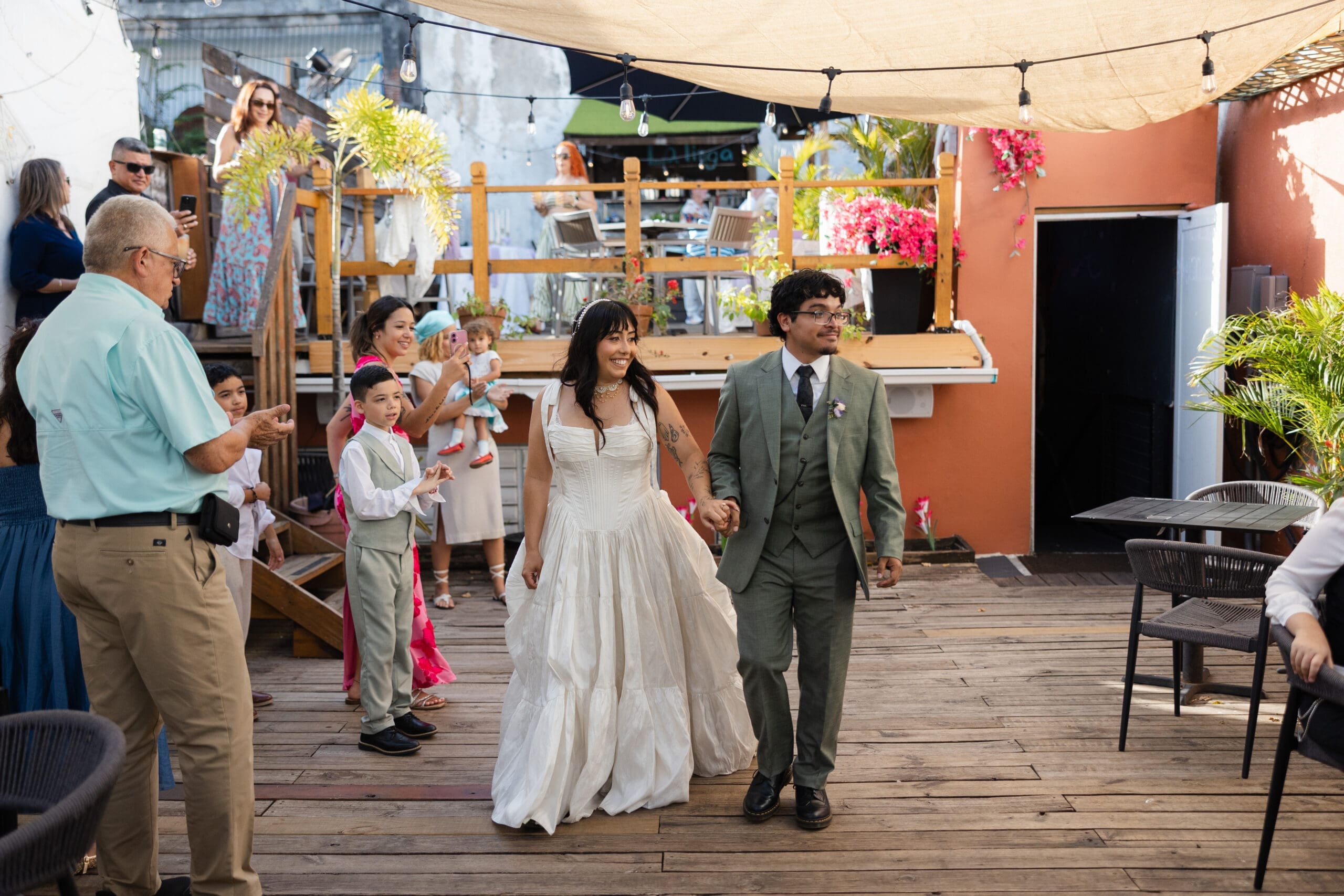 Newlyweds walking hand in hand through their outdoor wedding reception venue in San Juan, Puerto Rico