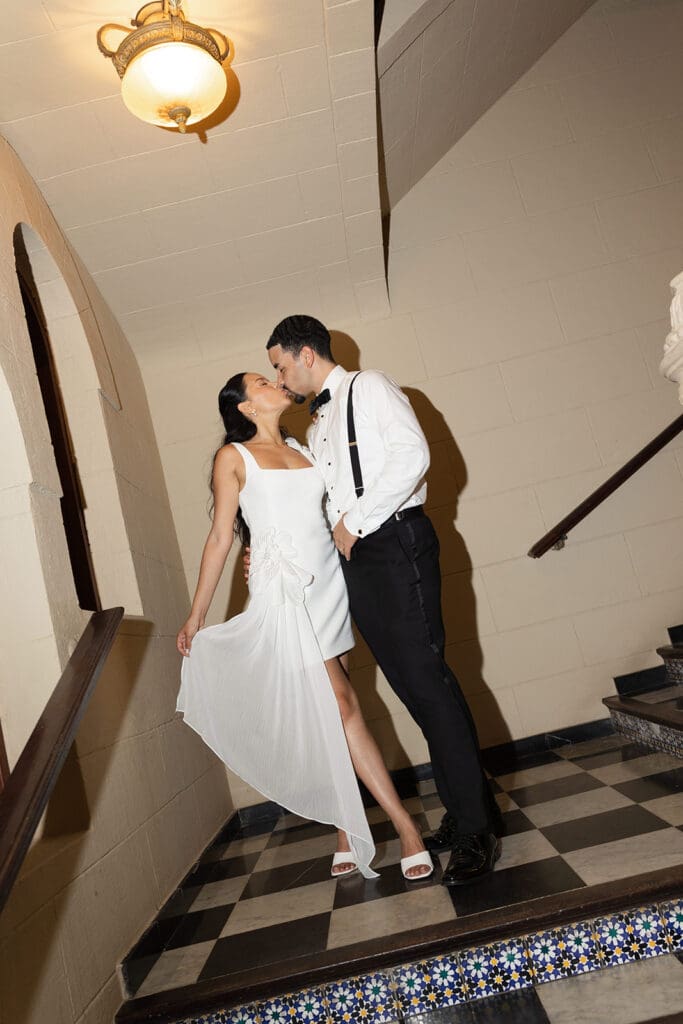 Bride and groom kissing on a tiled staircase at Casa de España in Puerto Rico.