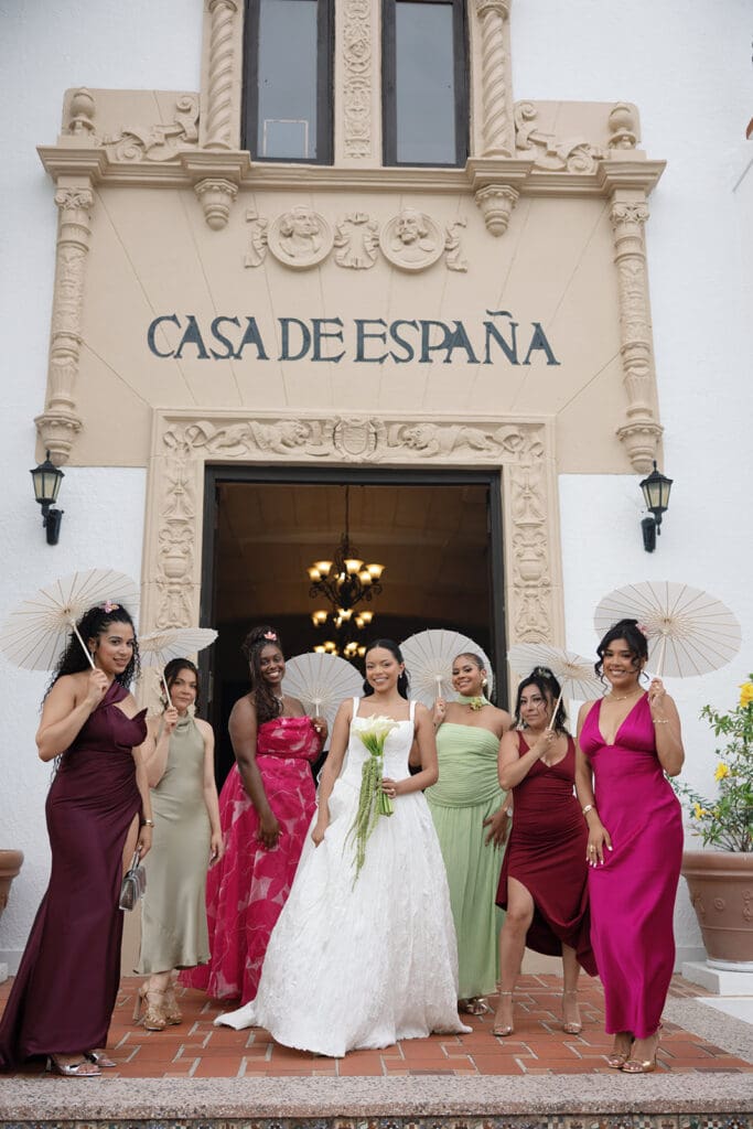 Bride poses with her wedding party in colorful attire outside Casa de España in Puerto Rico.