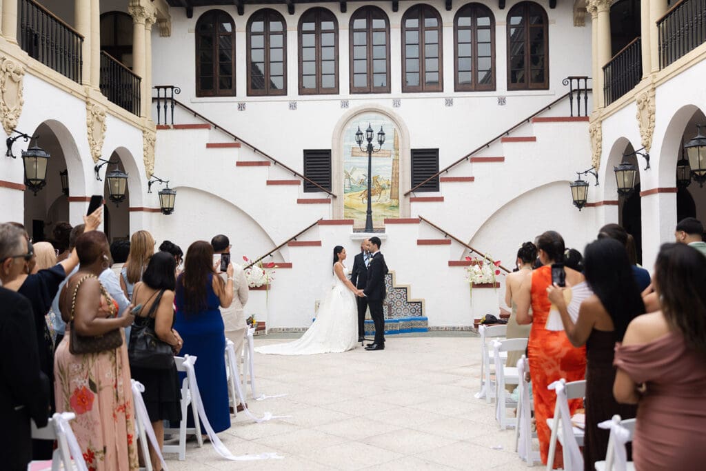 Bride and groom exchange vows during their courtyard wedding ceremony at Casa de España in Puerto Rico.