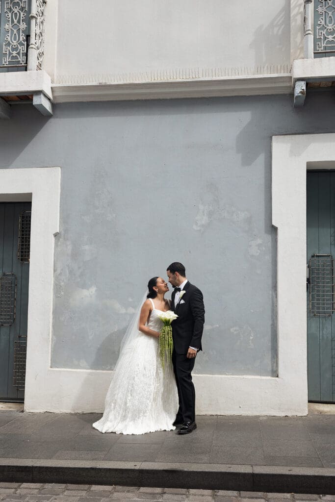 Bride and groom lean in for a kiss during their wedding portraits on a street in Old San Juan.