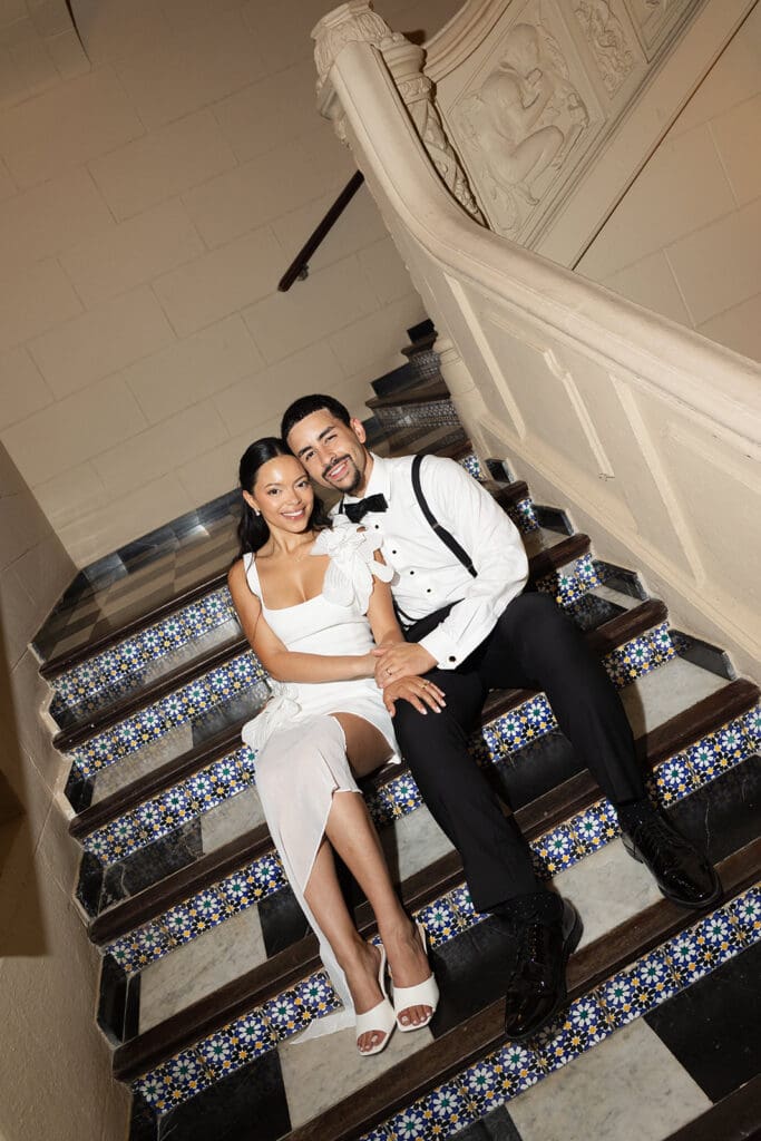 Bride and groom sitting together for a wedding portrait on the colorful tiled staircase at Casa de España.