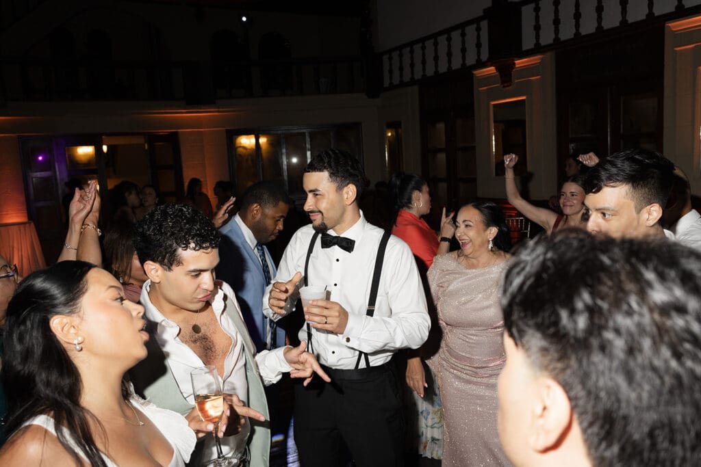 Groom dancing with wedding guests during the evening reception.
