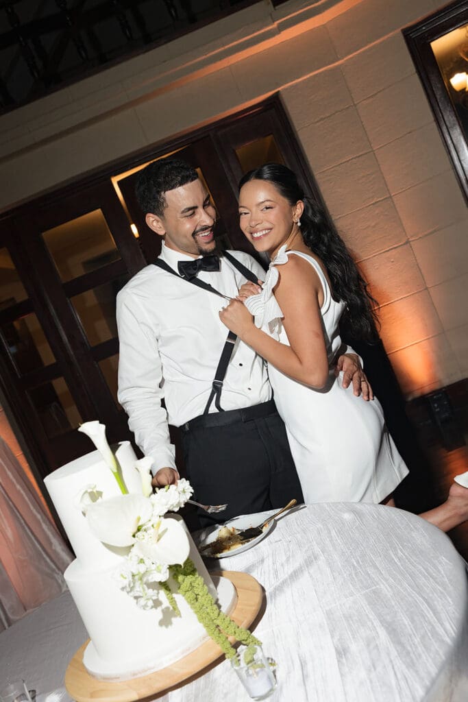 Bride and groom smiling together after cutting their wedding cake at the reception.