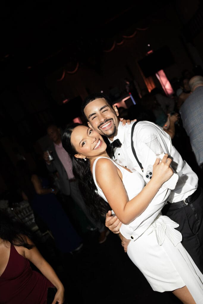 Newlyweds hugging and smiling together on the dance floor during their Casa de España wedding reception.