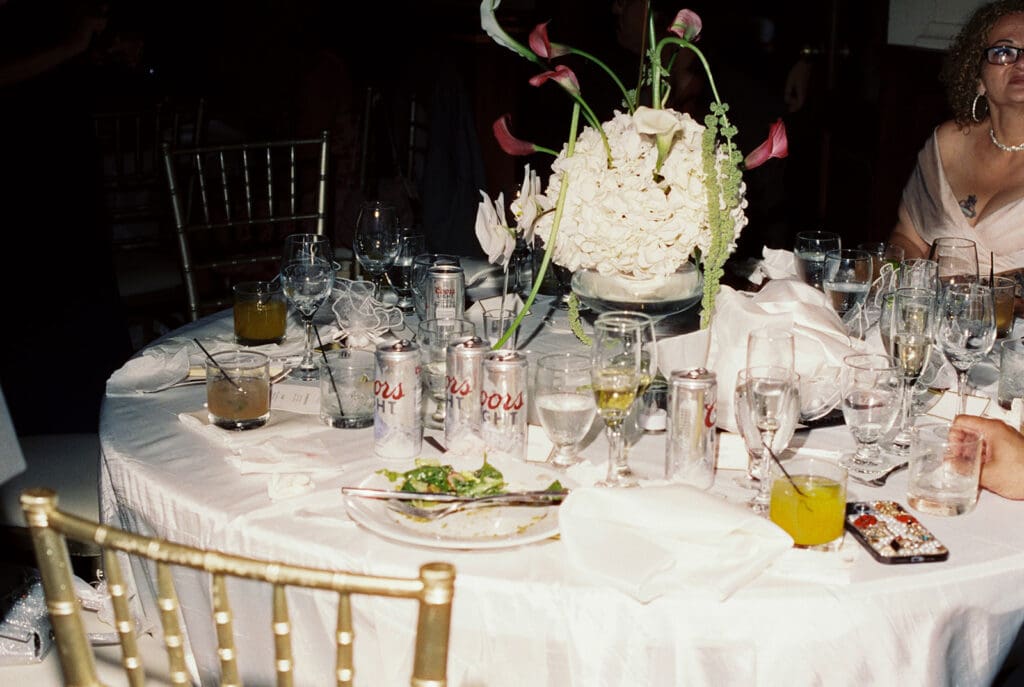 Wedding reception table with white hydrangeas, pink calla lilies, and green floral accents.