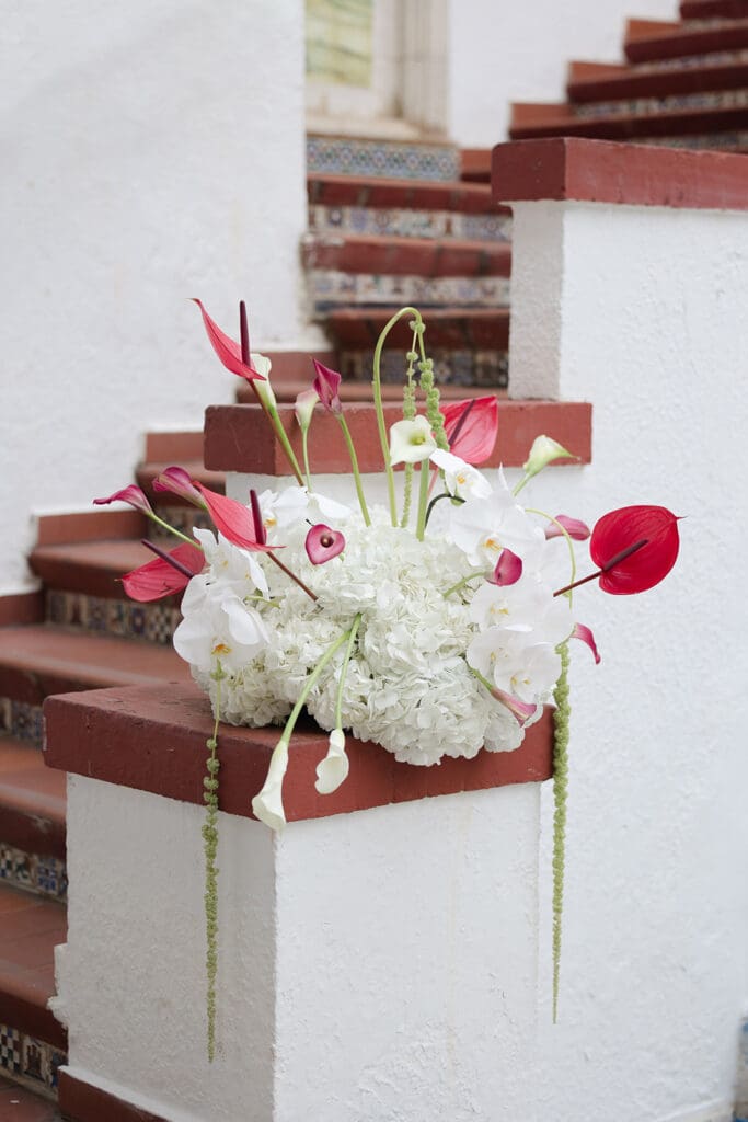 White hydrangeas and orchids with pink anthuriums and trailing greenery decorate the tiled ceremony staircase.
