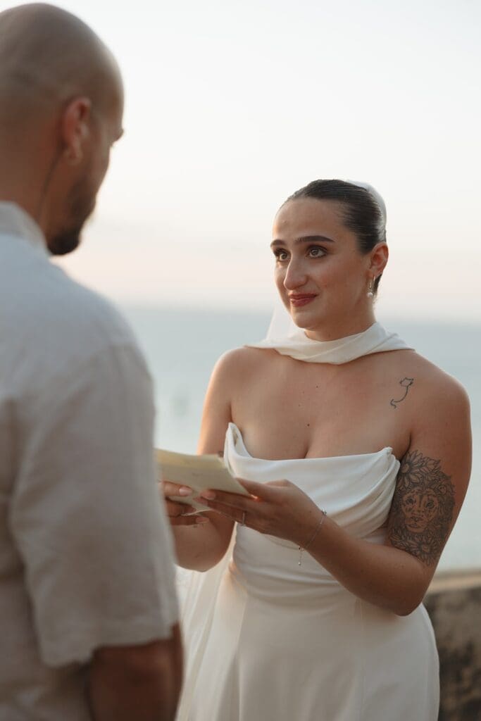 Bride smiling at her partner during an intimate Puerto Rico elopement ceremony by the water.