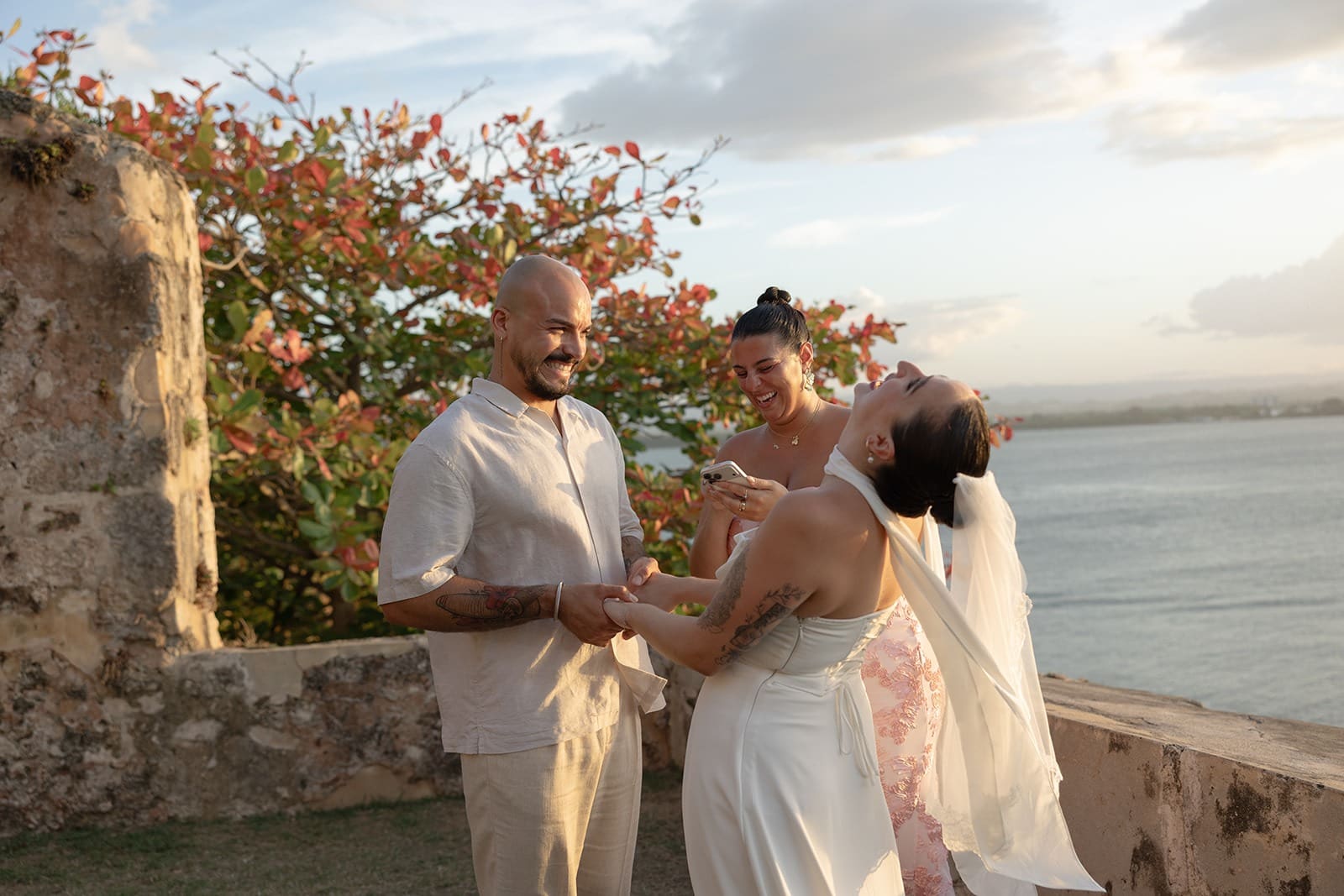 Bride laughing while holding hands with her partner during their sunset elopement ceremony in Puerto Rico.
