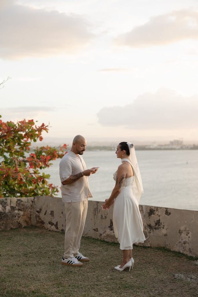 Couple exchanging vows during their Puerto Rico elopement overlooking the ocean in Old San Juan.