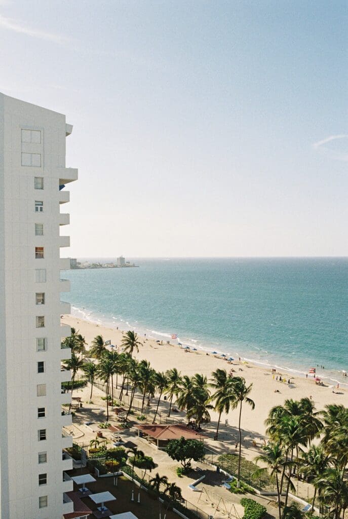 Aerial view of a palm-lined beach and turquoise ocean in San Juan, Puerto Rico.
